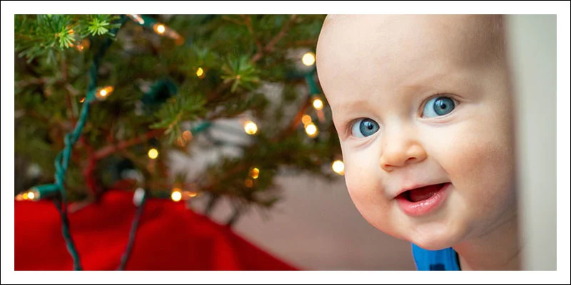 Photograph of baby's face in front of christmas lights